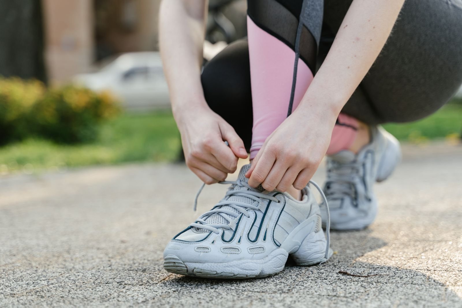 A person tying the laces of cushioned walking shoes
